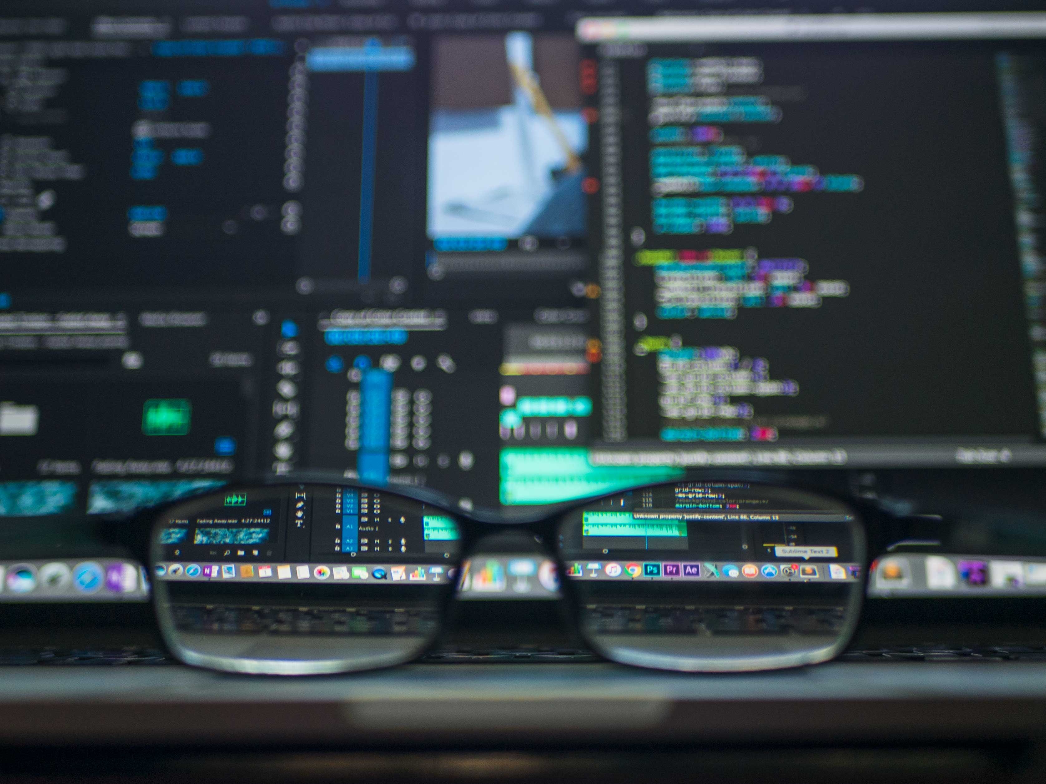 glasses in front of a computer with a coding application open